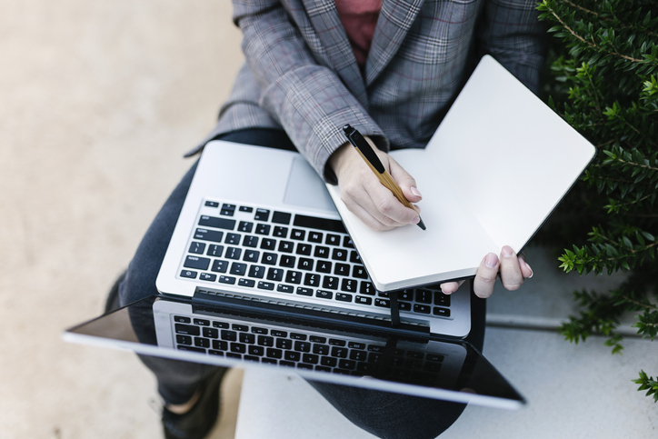 Journalist with a laptop and notepad out