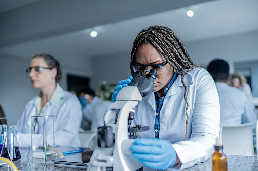 girl in class looking in microscope
