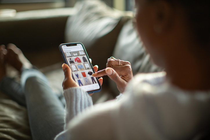 Woman scrolling and looking at clothes on phone